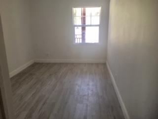 An empty room with light wood-look flooring, white walls, and a single window — 407 S Lakeside Drive # A, FL 33460, FL
