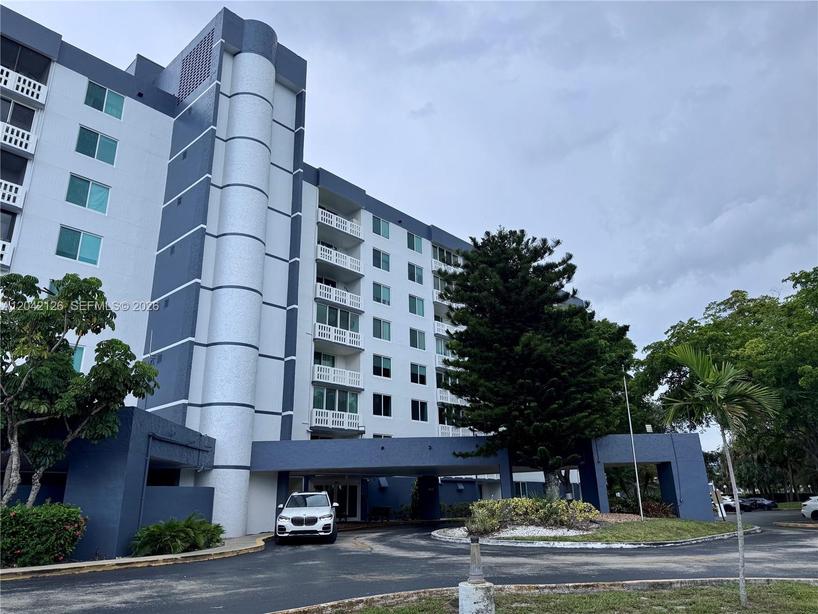 A multi-story apartment building with a white and blue facade features a covered entrance — 919 Hillcrest Dr # 102, Hollywood FL 33021, HOLLYWOOD, FL