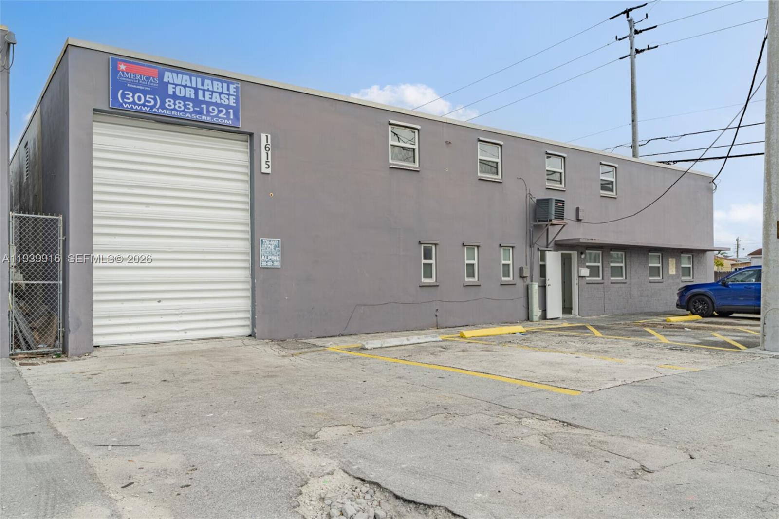 A gray industrial building features a large roll-up door, multiple windows, and a parking area — 1615 W 31st Pl, Hialeah FL 33012, HIALEAH, FL