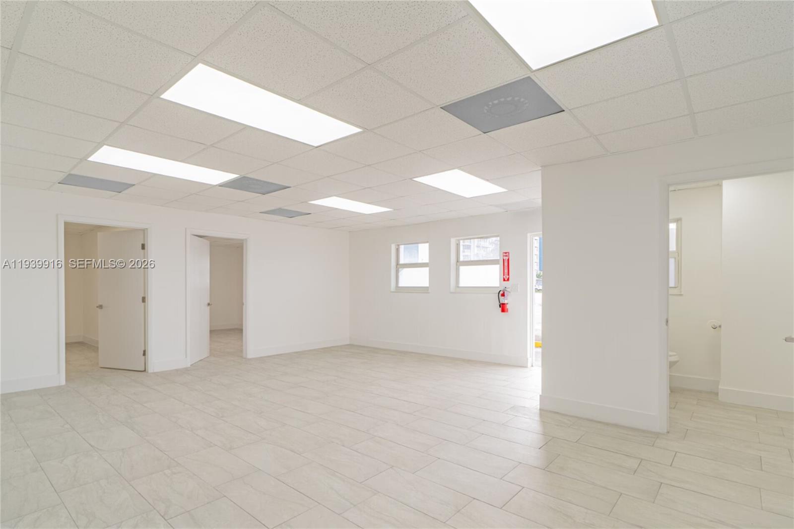 A bright, empty office space features white walls, tiled floors, and a drop ceiling — 1615 W 31st Pl, Hialeah FL 33012, HIALEAH, FL
