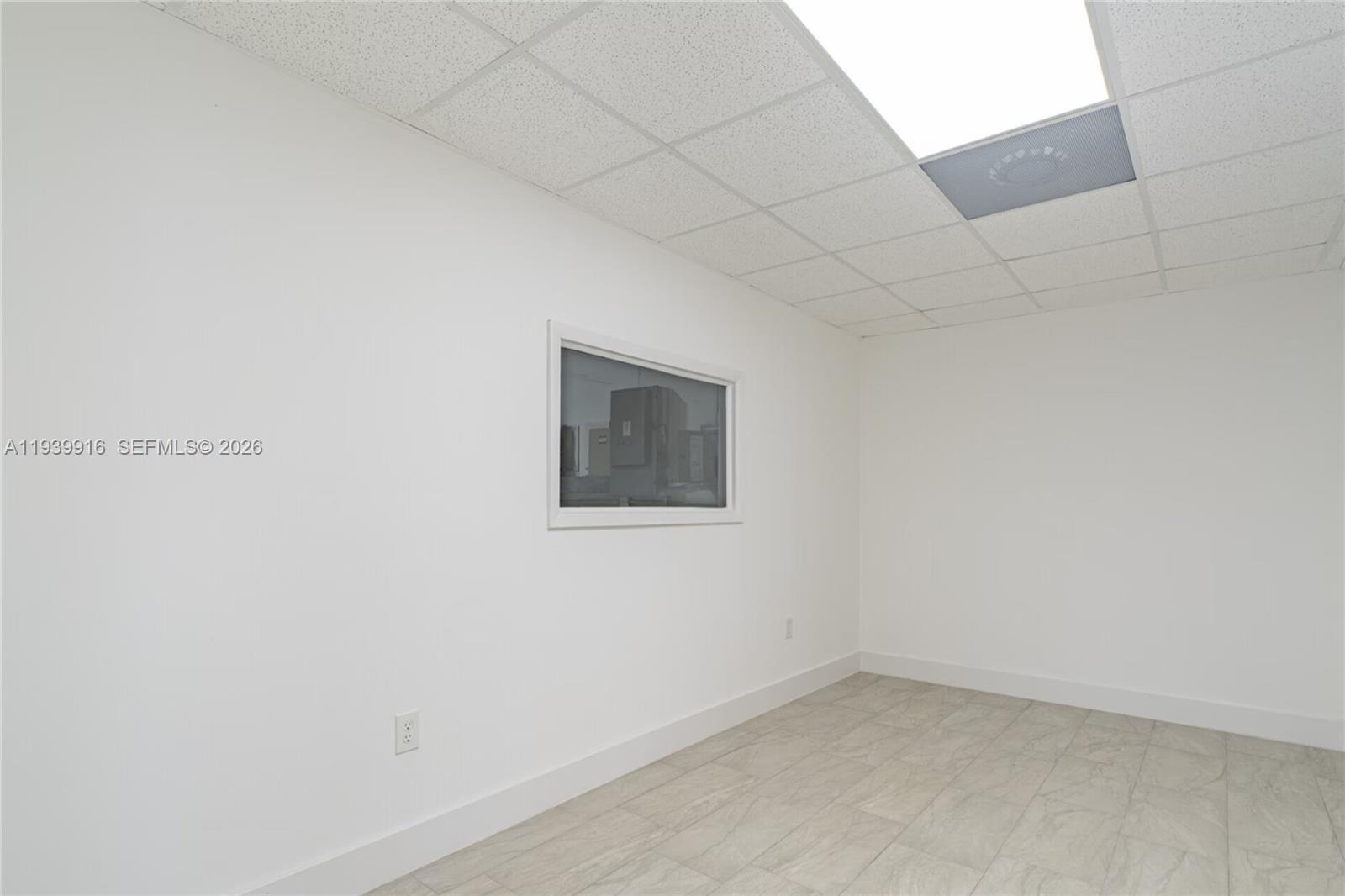 This room features white walls, a drop ceiling with a light panel, and tiled flooring — 1615 W 31st Pl, Hialeah FL 33012, HIALEAH, FL