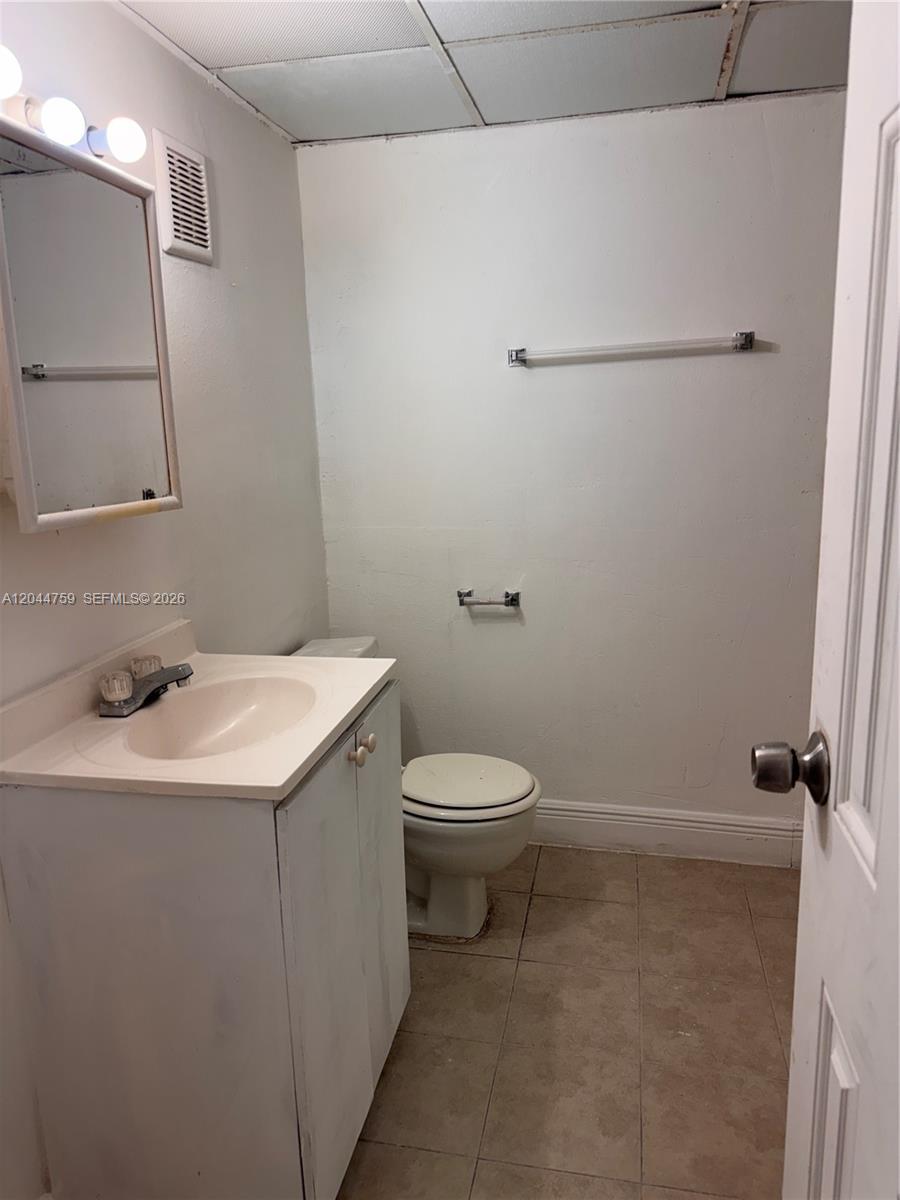 A small bathroom features a white vanity, a toilet, and a wall-mounted towel bar — 1756 NW 55th Ave # 101, Lauderhill FL 33313, LAUDERHILL, FL