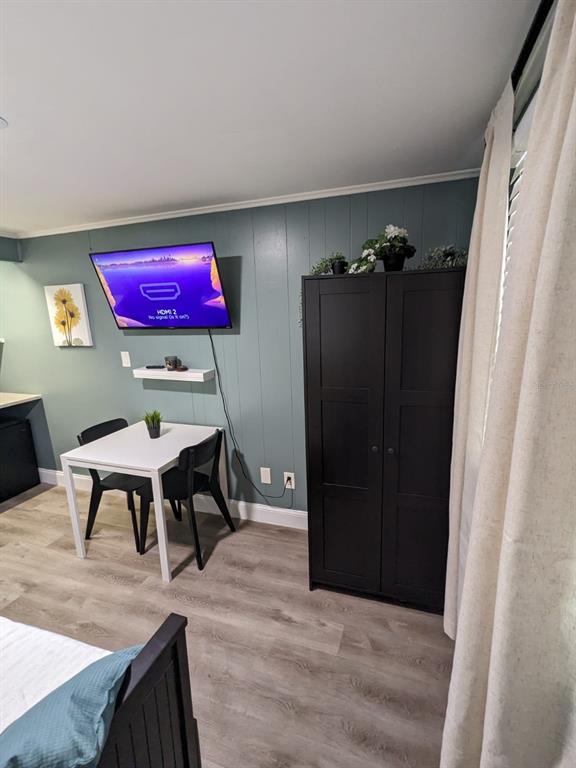 A room features a wall-mounted television, a small dining table with two chairs, and a wardrobe — 4538 W MINNEHAHA STREET UNIT C, TAMPA, FL