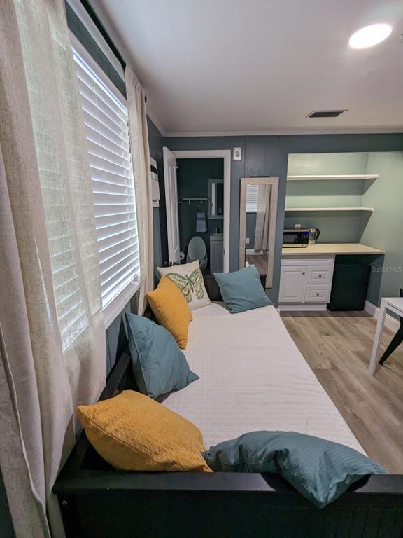 A room features a daybed with colorful pillows, a small kitchenette, and a bathroom doorway — 4538 W MINNEHAHA STREET UNIT C, TAMPA, FL