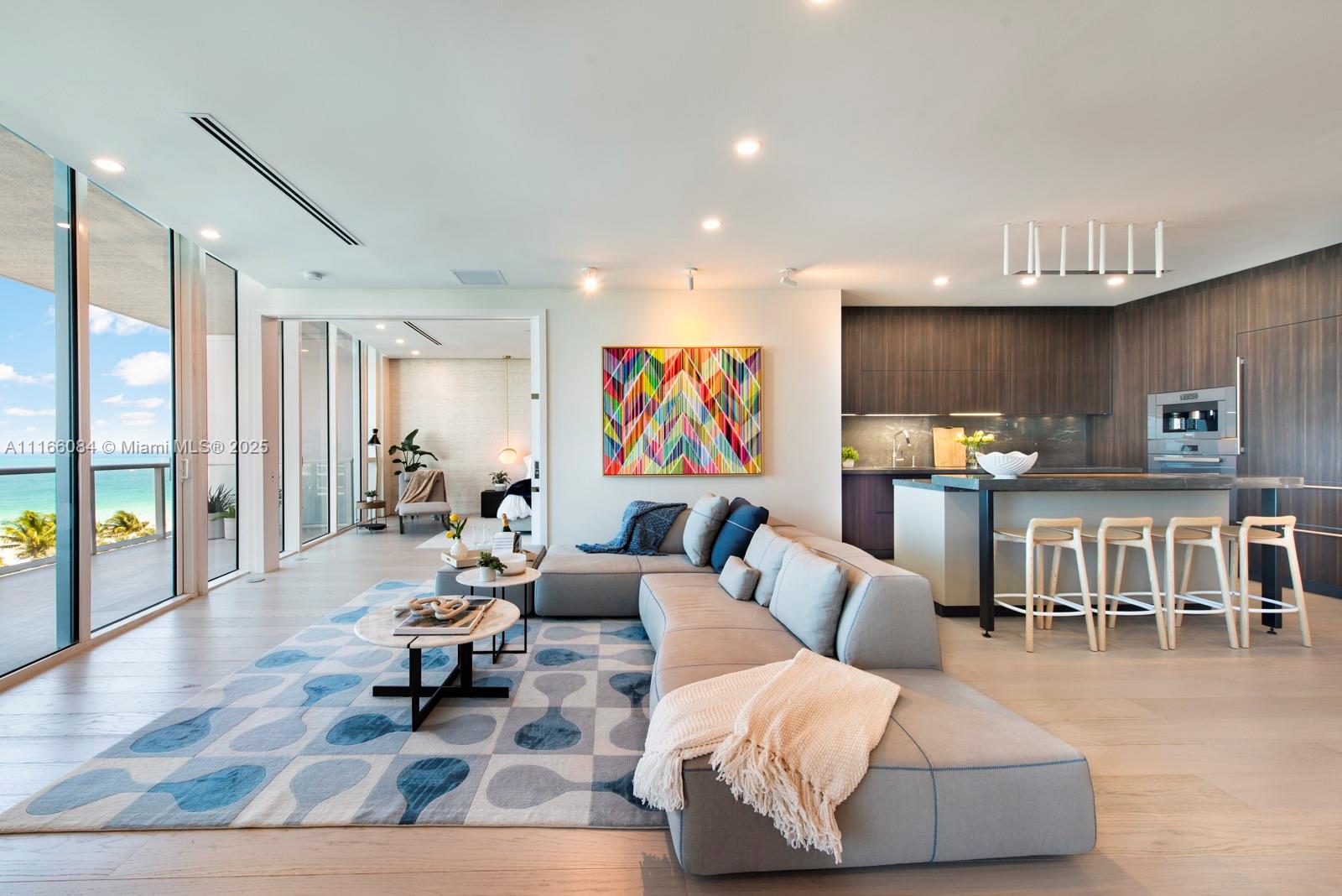 A modern open-concept living room and kitchen feature floor-to-ceiling windows with ocean views — 100 S Pointe Dr # 908, Miami Beach FL 33139, MIAMI BEACH, FL