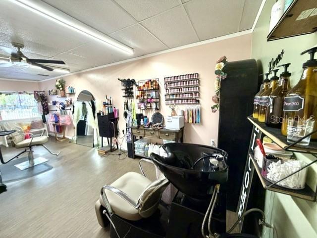 A hair salon features a shampoo station, styling chair, product shelves, and a ceiling fan — 1180 S MAIN STREET, BELL, FL