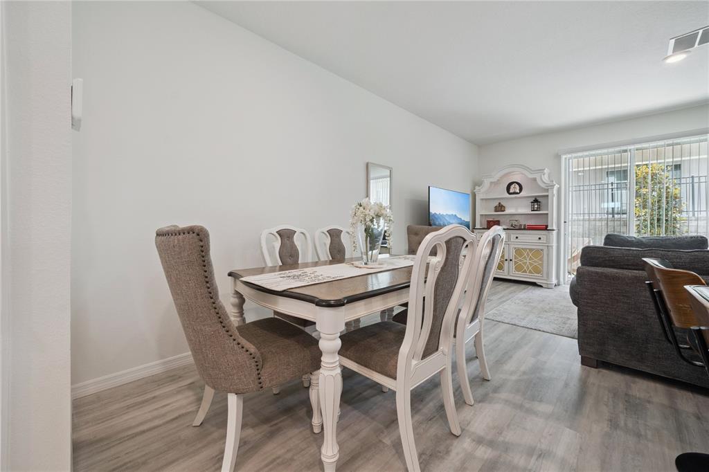 A dining area features a wooden table with upholstered chairs and a white hutch nearby — 2076 MONTEVERDE AVENUE, DAVENPORT, FL
