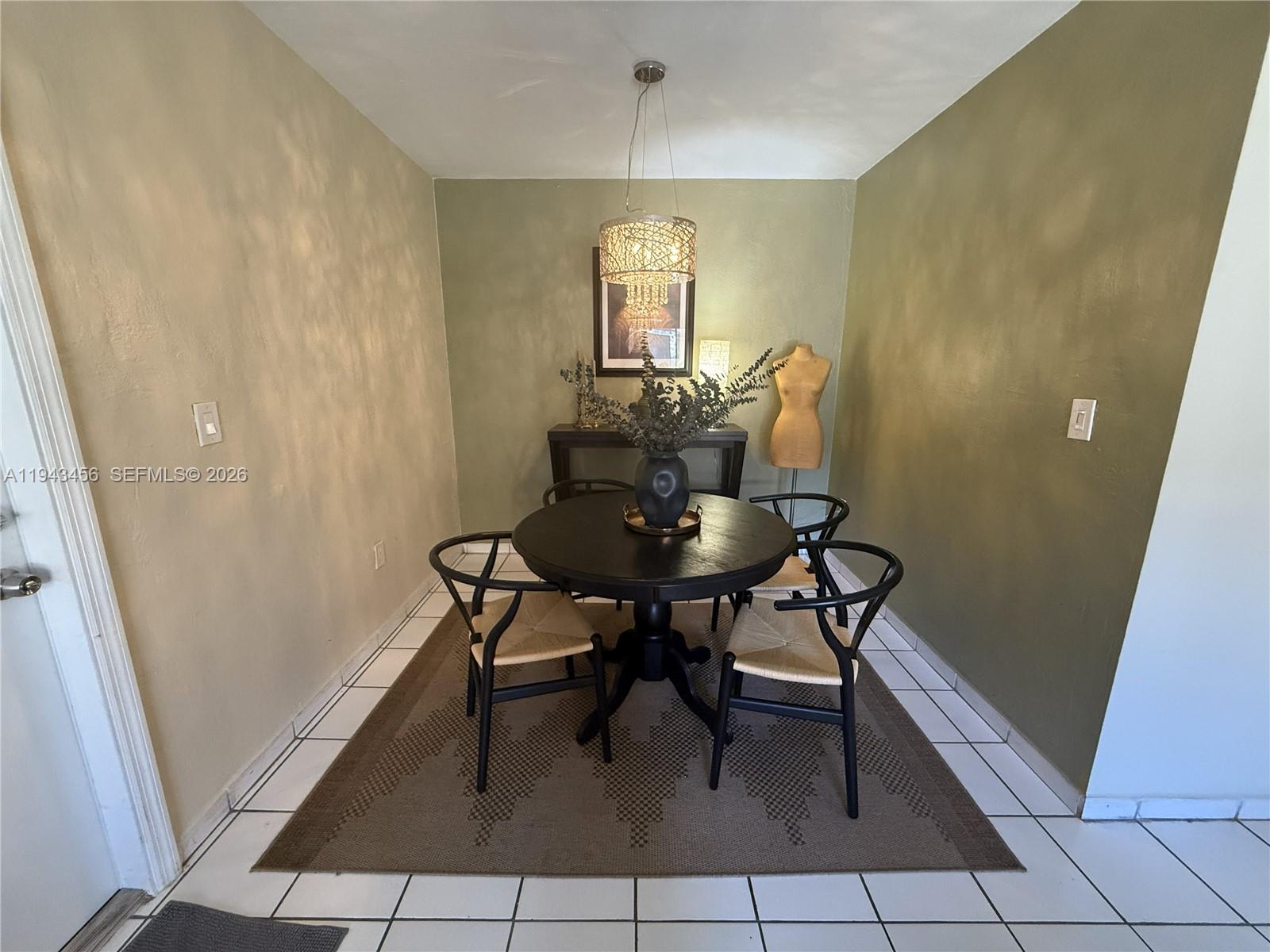 A dining room features a round black table, four chairs, and a decorative pendant light — 7823 Miller Dr # C207, Miami FL 33155, MIAMI, FL