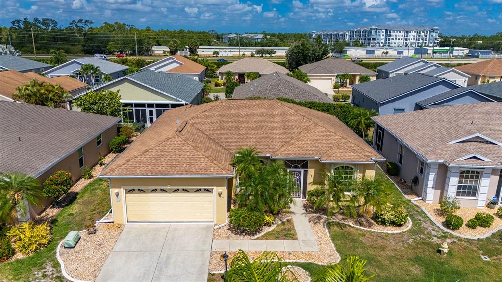 An aerial view shows a tan single-story house with a brown roof and garage — 1637 PALACE COURT, PORT CHARLOTTE, FL