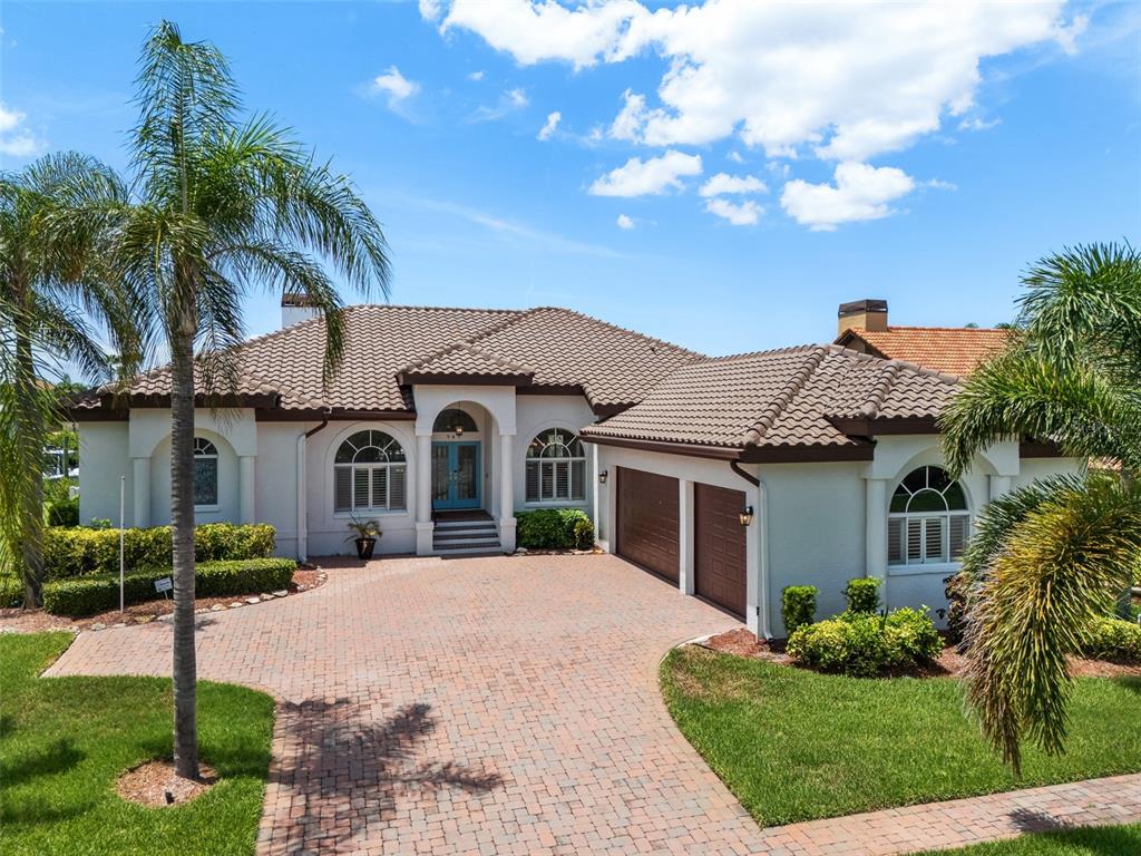 A single-story house with a tiled roof, brick driveway, and two-car garage — 949 ALLEGRO LANE, APOLLO BEACH, FL