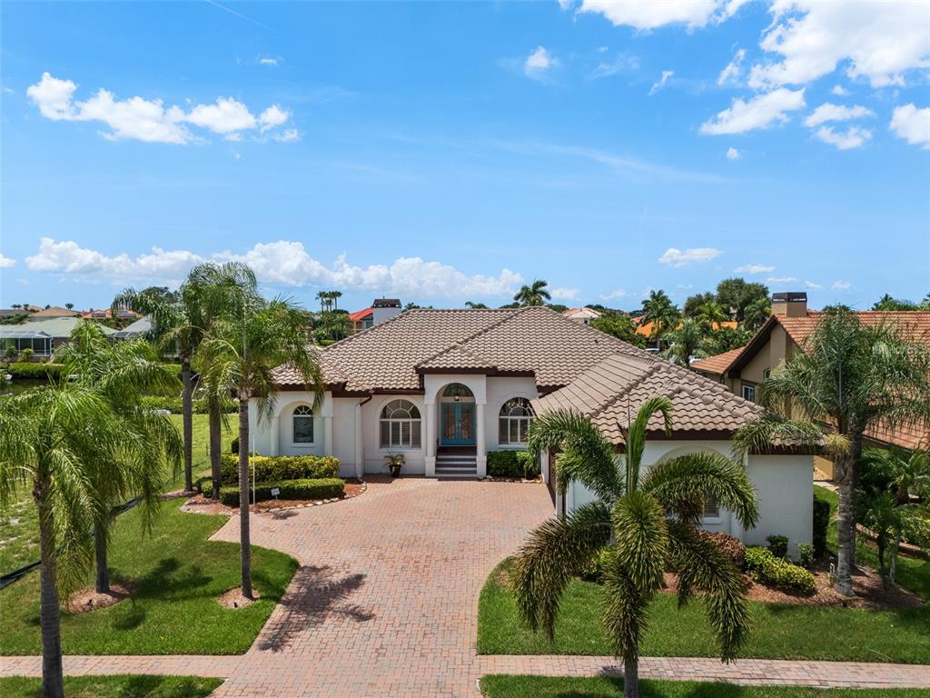 An aerial view shows a single-story house with a tile roof and brick paver driveway — 949 ALLEGRO LANE, APOLLO BEACH, FL