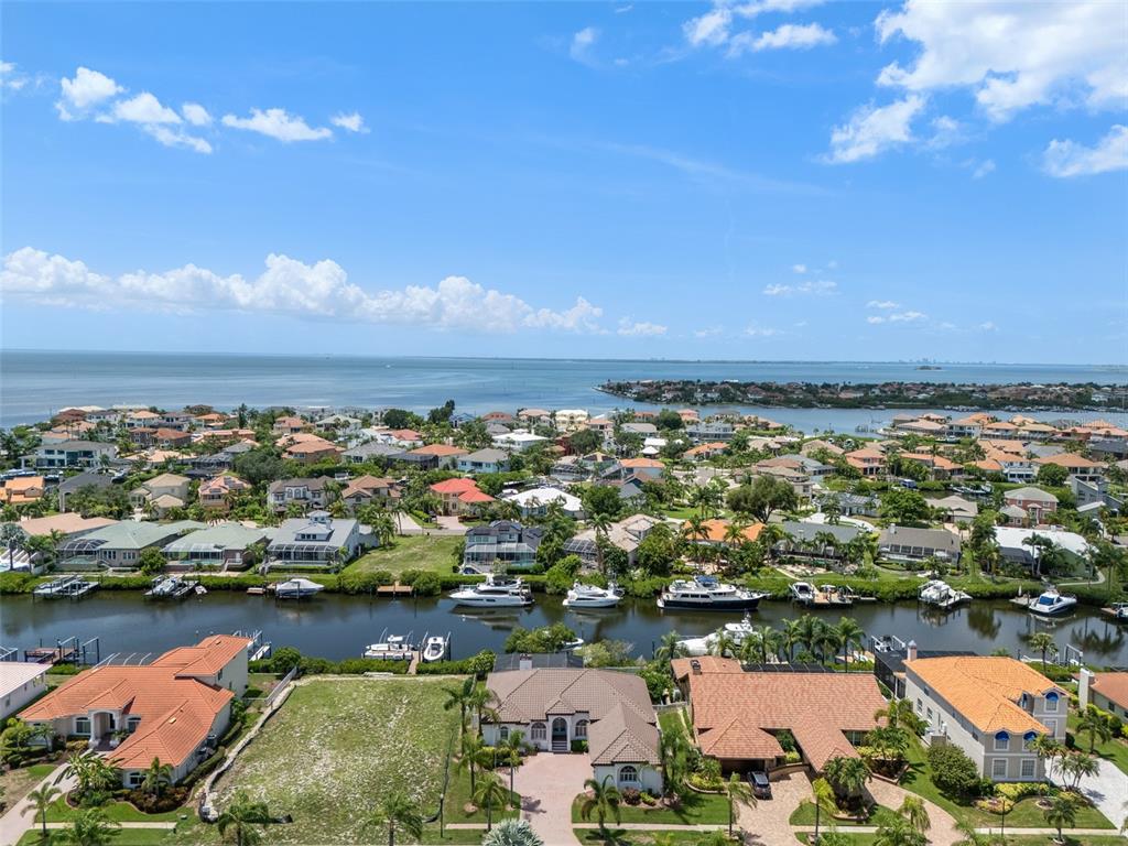 An aerial view shows waterfront houses along a canal leading to a large bay — 949 ALLEGRO LANE, APOLLO BEACH, FL