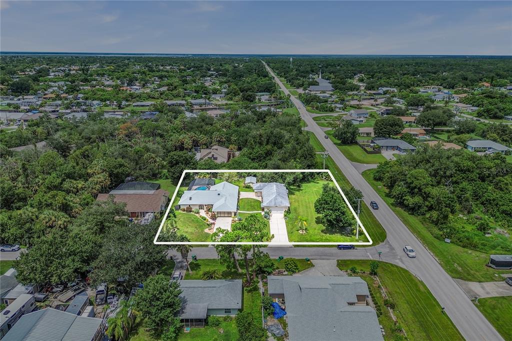 An aerial view shows a residential property with a house, pool, and lawn — 19217 ABHENRY CIRCLE, PORT CHARLOTTE, FL
