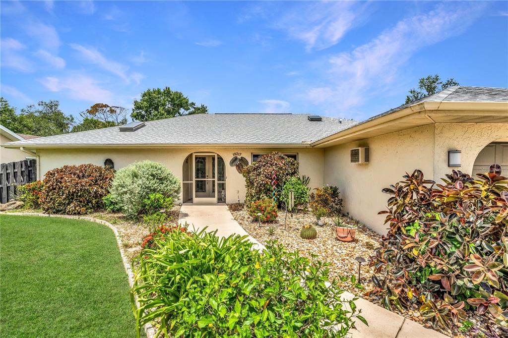 A single-story house with a light-colored exterior, a gray roof, and a landscaped front yard — 19217 ABHENRY CIRCLE, PORT CHARLOTTE, FL