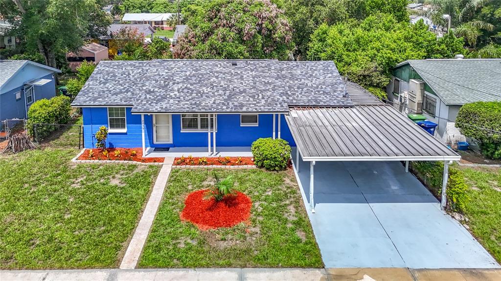 An aerial view of a bright blue house with a gray shingled roof and carport — 4416 N JOHN BELL JR DRIVE, TAMPA, FL