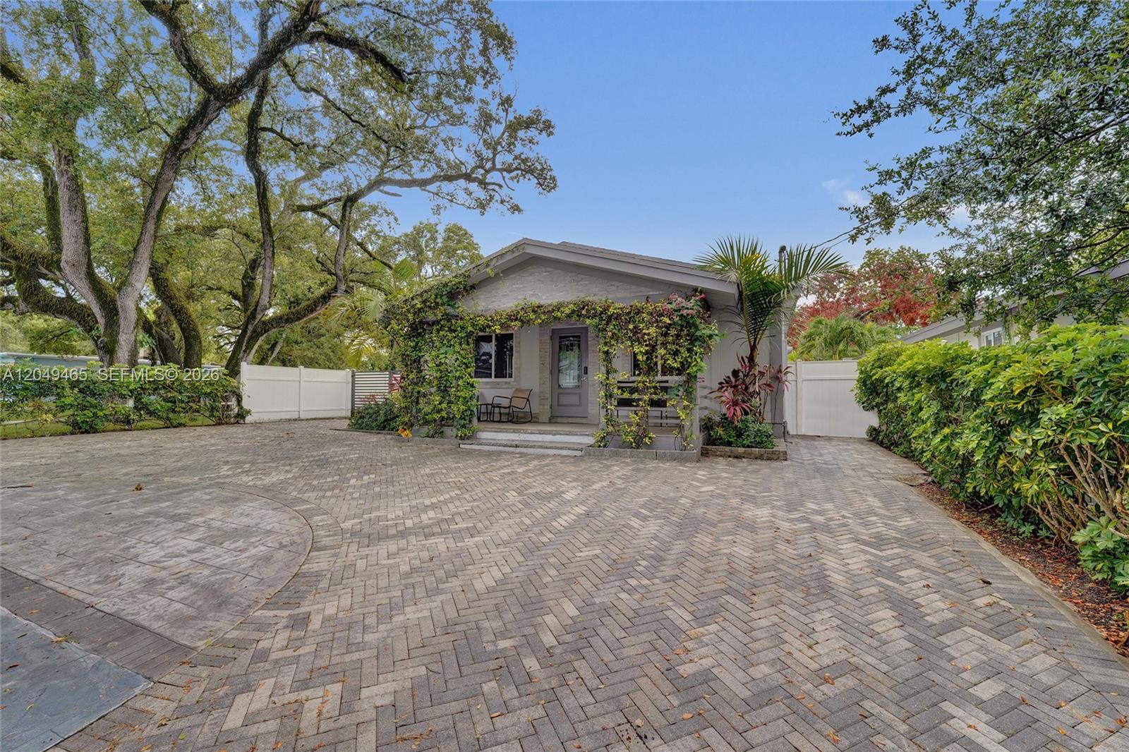 A single-story house with a paved driveway, climbing vines, and mature trees in the yard — 4541 SW 26th Ter # 0, Dania Beach FL 33312, DANIA BEACH, FL