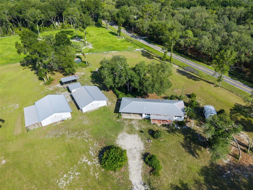 An aerial view shows a house and several outbuildings on a large, grassy rural lot — 12450 NW 85TH AVENUE, CHIEFLAND, FL