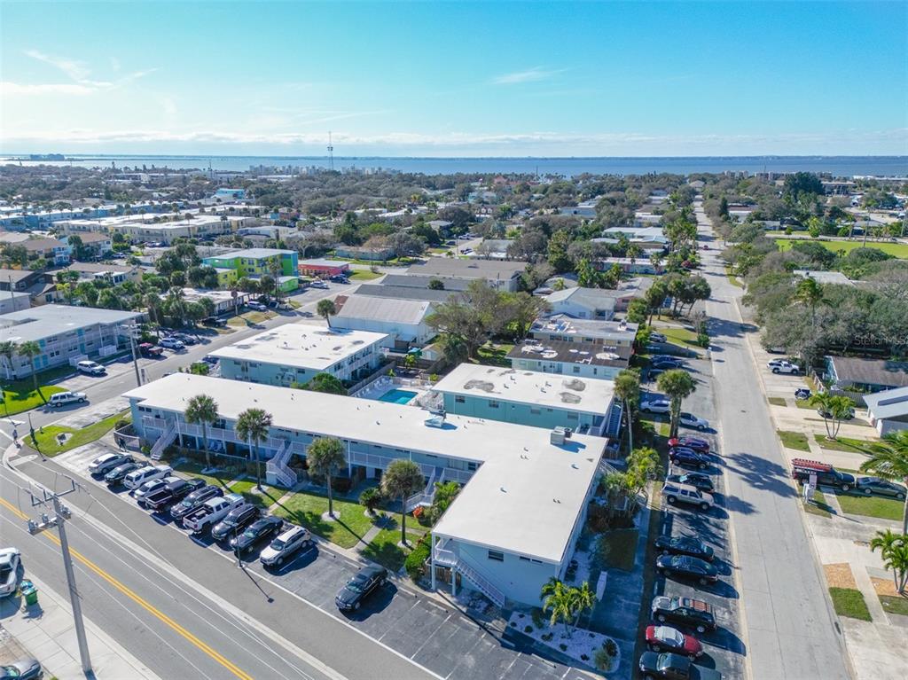 An aerial view shows a multi-story apartment complex with parking lots and a swimming pool — 425 HARRISON AVENUE UNIT 6-2, CAPE CANAVERAL, FL
