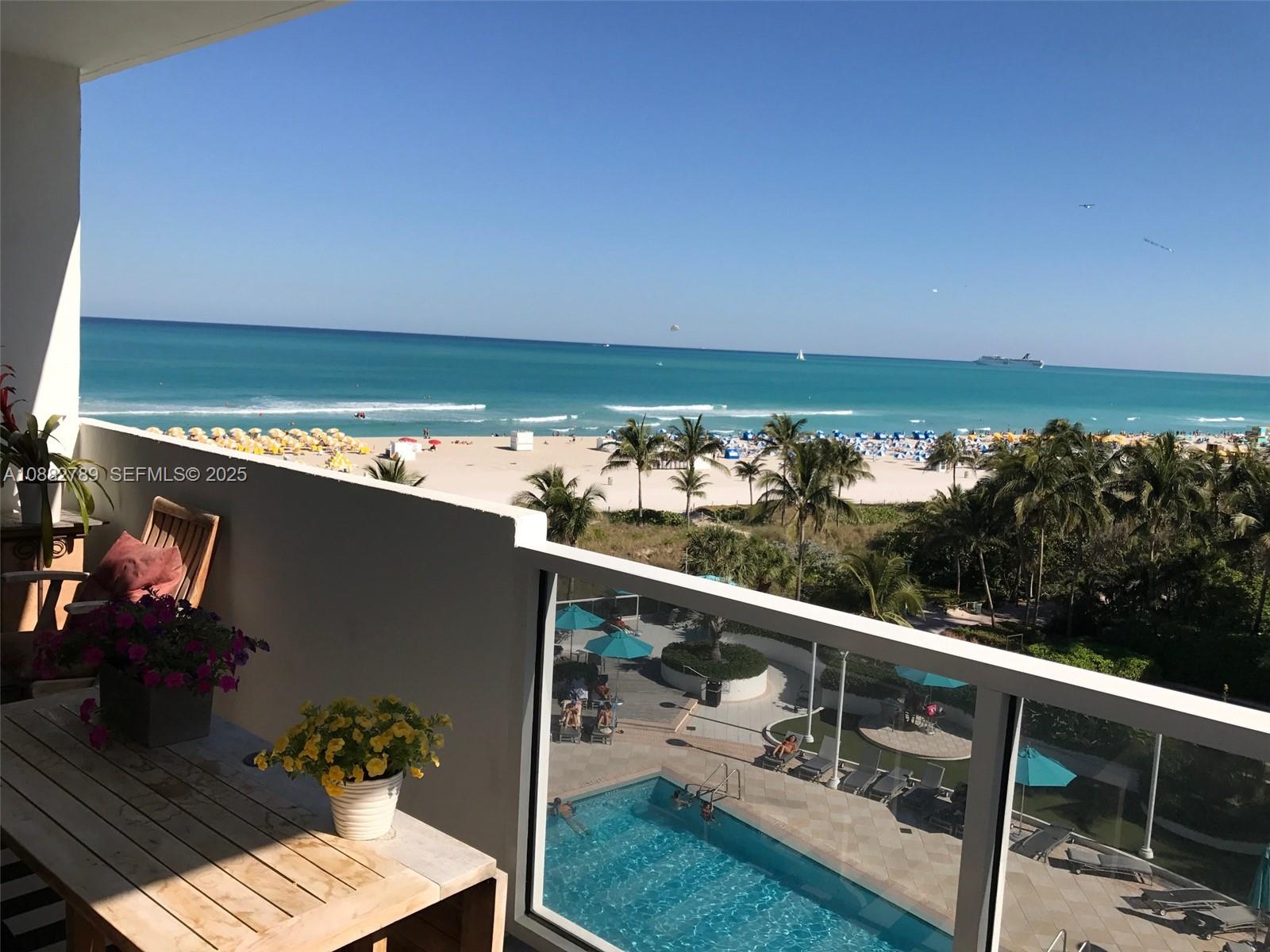A balcony overlooks a swimming pool, palm trees, a sandy beach, and the ocean — 100 Lincoln Rd # 644, Miami Beach FL 33139, MIAMI BEACH, FL