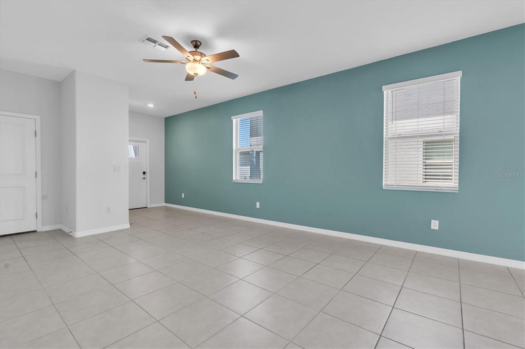A kitchen and dining area featuring white cabinets, stainless steel appliances, and tile flooring — 8299 BIRCH HAVEN LANE, NEW PORT RICHEY, FL