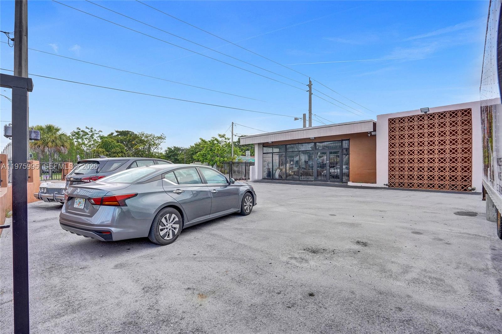 A gray sedan is parked in front of a commercial building with a decorative screen — 5595 NW 17th Ave, Miami FL 33142, MIAMI, FL