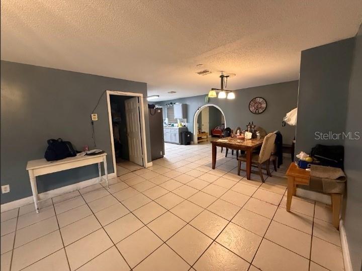 A dining area and kitchen are visible with tiled floors, an arched doorway, and blue walls — 2533 EL PORTAL AVENUE, SANFORD, FL