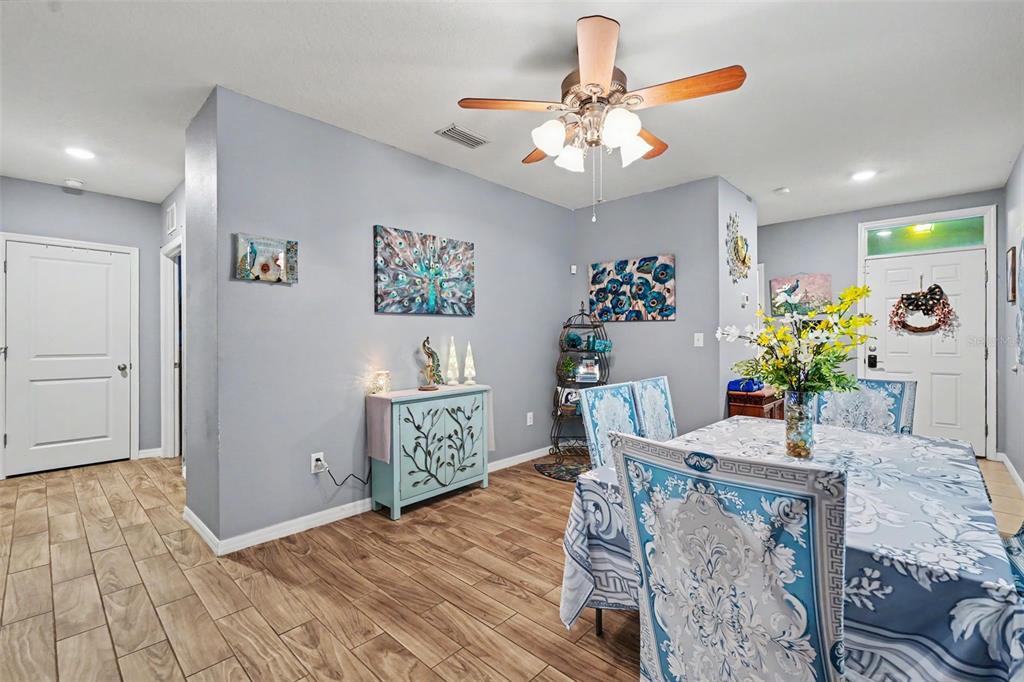 A dining room with light blue walls, wood-look tile flooring, and a patterned tablecloth — 3918 WILLOW HAMMOCK DRIVE, PALMETTO, FL