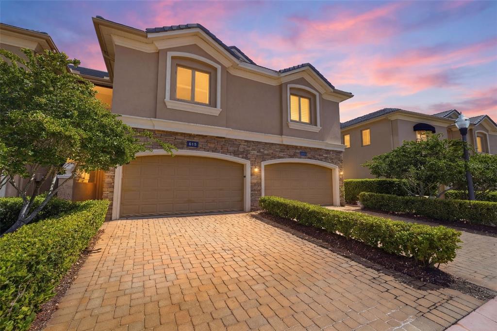 A two-story house with a stone facade, two garage doors, and a paved driveway — 615 SAXONY BOULEVARD, ST PETERSBURG, FL