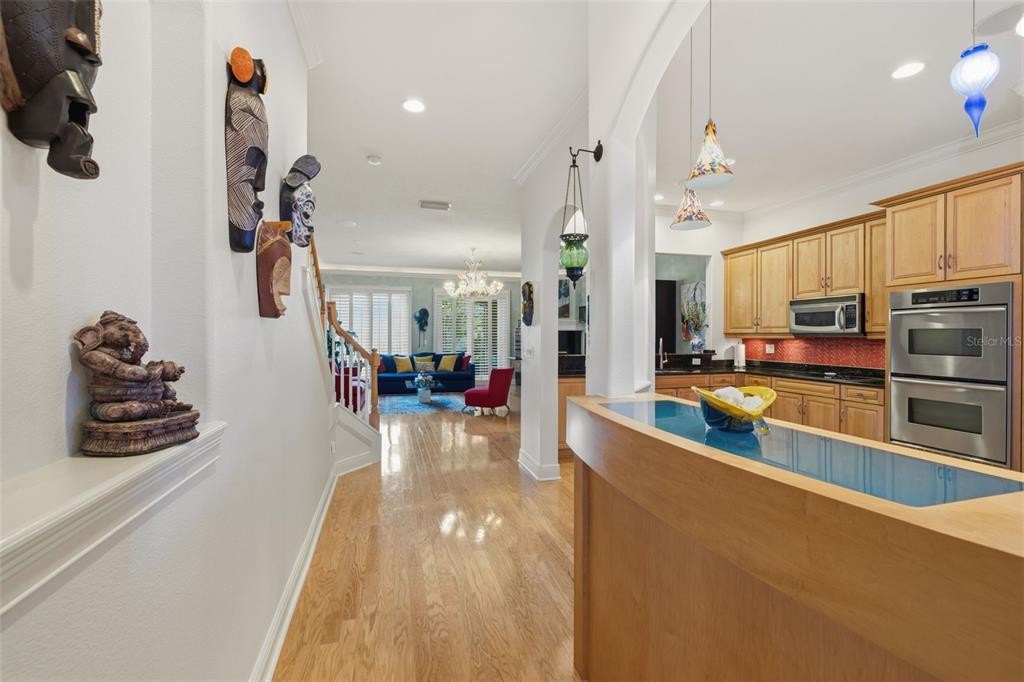 A view from a kitchen counter looking toward a living room with hardwood floors — 615 SAXONY BOULEVARD, ST PETERSBURG, FL