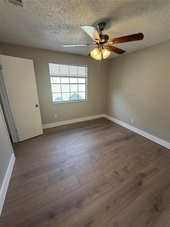 An empty bedroom features wood-look laminate flooring, a ceiling fan, and a single window — 3009 S MANHATTAN AVENUE UNIT B, TAMPA, FL