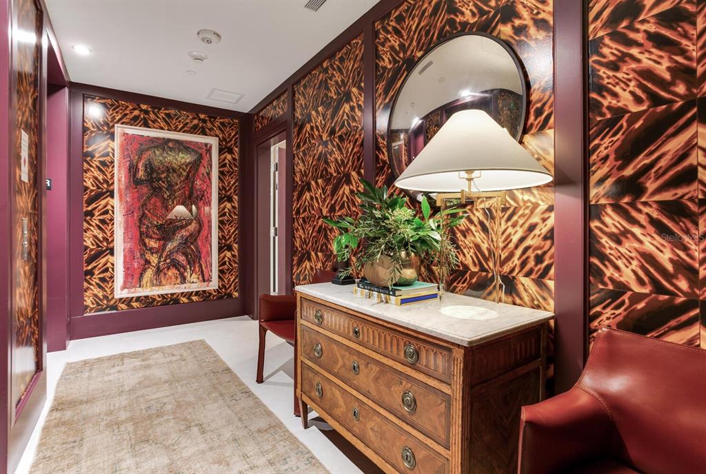 A hallway features bold patterned wallpaper, a wooden chest of drawers, and a large painting — 3015 S YSABELLA AVENUE UNIT 904, TAMPA, FL