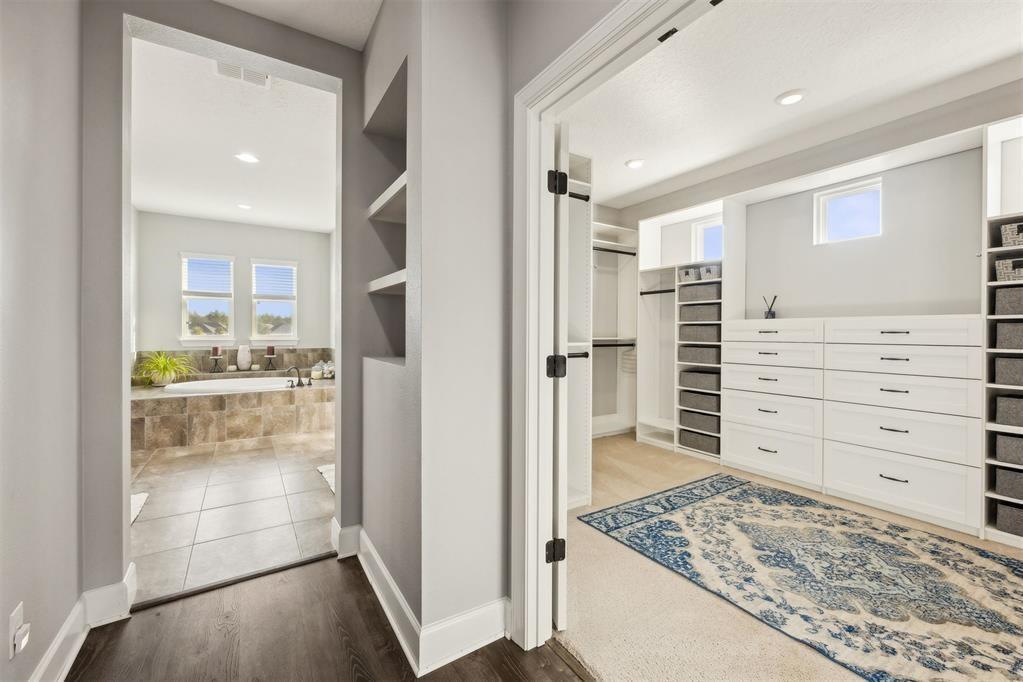 A walk-in closet with white cabinetry and a rug connects to a tiled bathroom — 85030 Majestic Walk Boulevard, FL 32034, FL