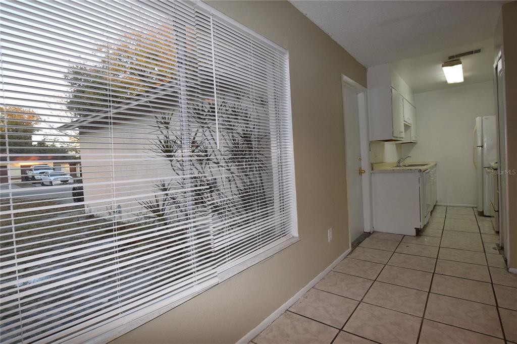 A tiled kitchen area features white cabinets, a sink, and a large window with blinds — 3115 SPLIT WILLOW DRIVE, ORLANDO, FL