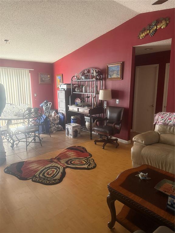 A living and dining area features red walls, light wood flooring, and a butterfly rug — 2507 MARTHA LANE, LAND O LAKES, FL