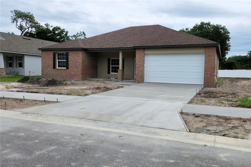 A single-story brick house with a two-car garage and a concrete driveway under construction — 411 SHANNON ESTATES COURT, PLANT CITY, FL