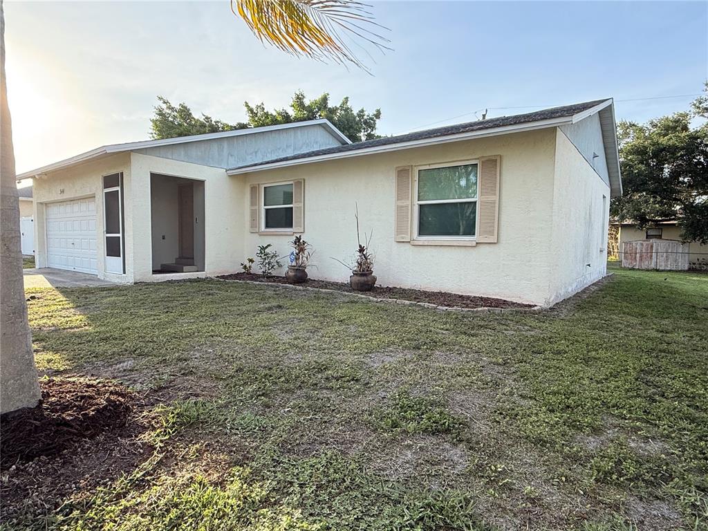 A single-story house with a light-colored stucco exterior, a garage, and a front lawn — 344 49TH STREET W, PALMETTO, FL