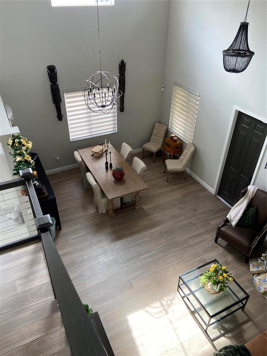 An elevated view of a dining and living area with wood floors and high ceilings — 20439 NW 9th Court, Miami FL 33169, MIAMI, FL