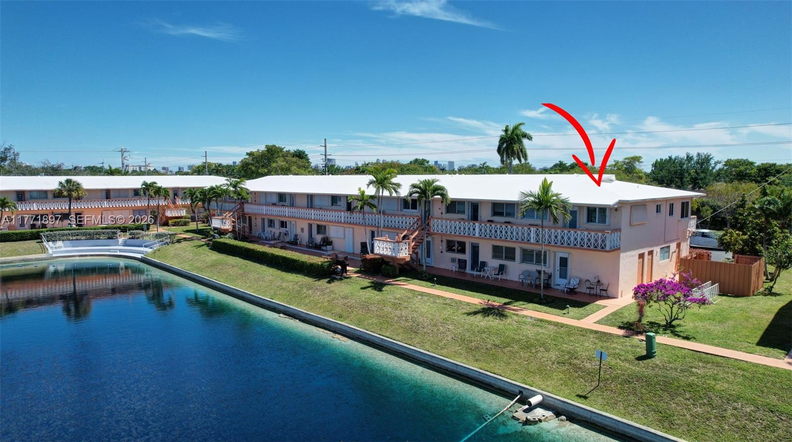 An aerial view shows a two-story apartment building with a white roof beside a canal — 1012 SW 11th St # 20N, Hallandale Beach FL 33009, HALLANDALE BEACH, FL