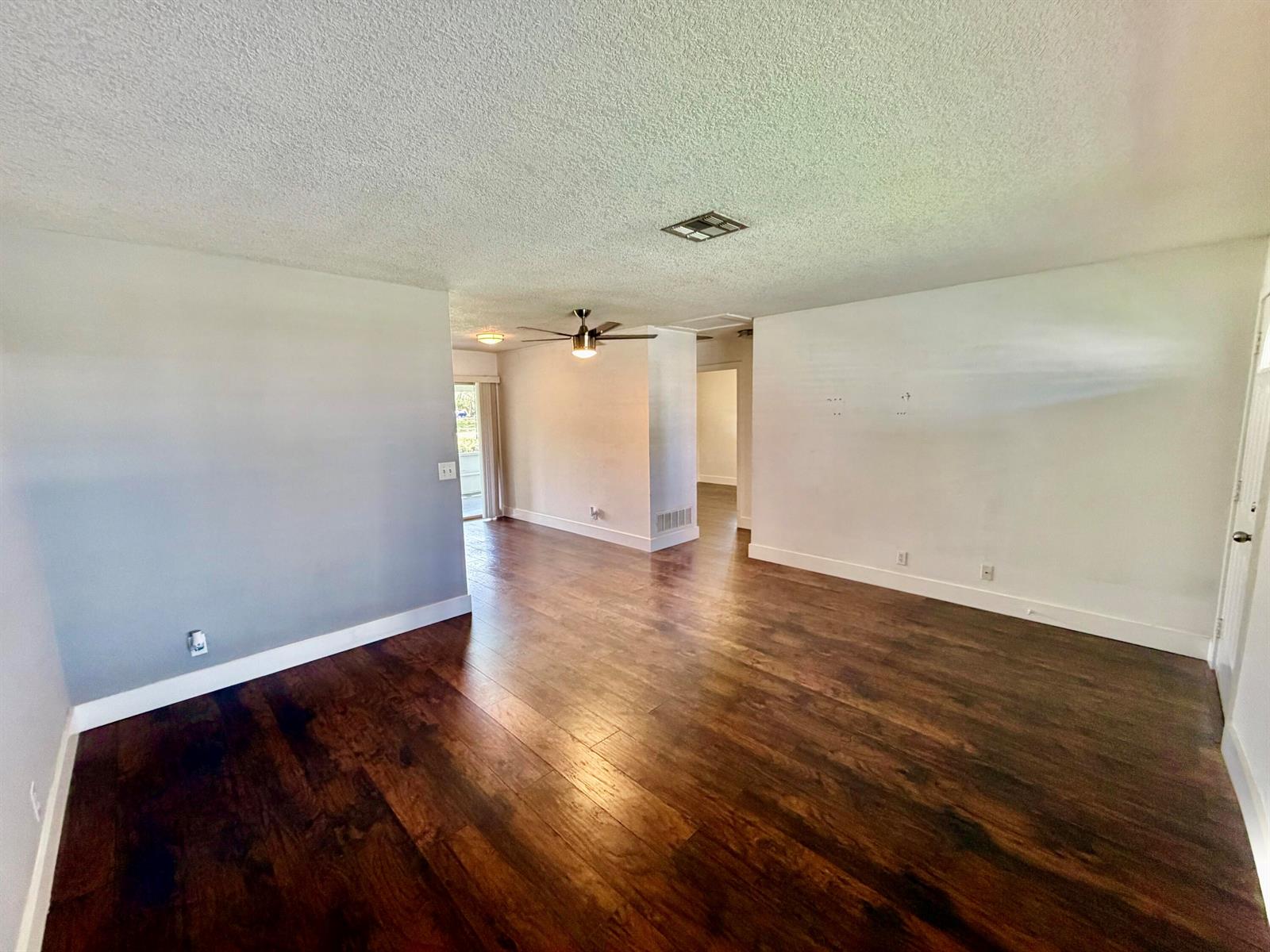 An interior view of a living room with dark wood flooring and white walls — 2821 Duke Lane, Delray Beach FL 33445, DELRAY BEACH, FL