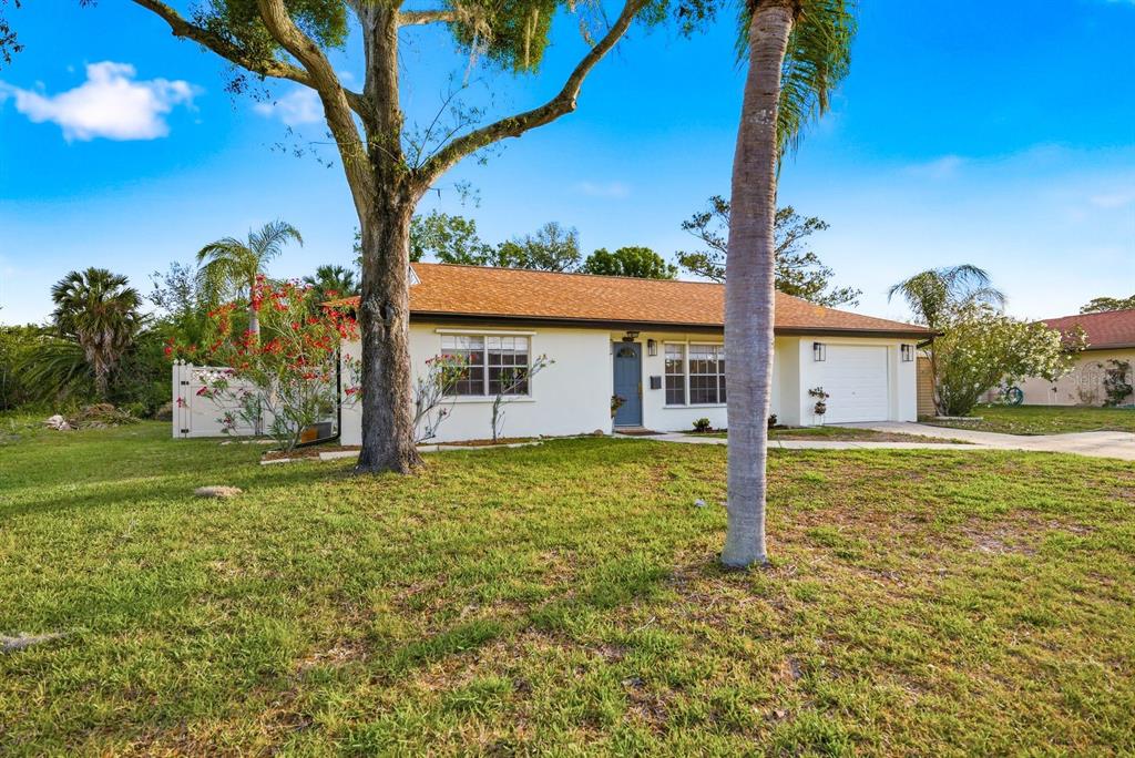 A single-story house with a white exterior, blue front door, and an attached one-car garage — 3705 GRAYTON DRIVE, NEW PORT RICHEY, FL