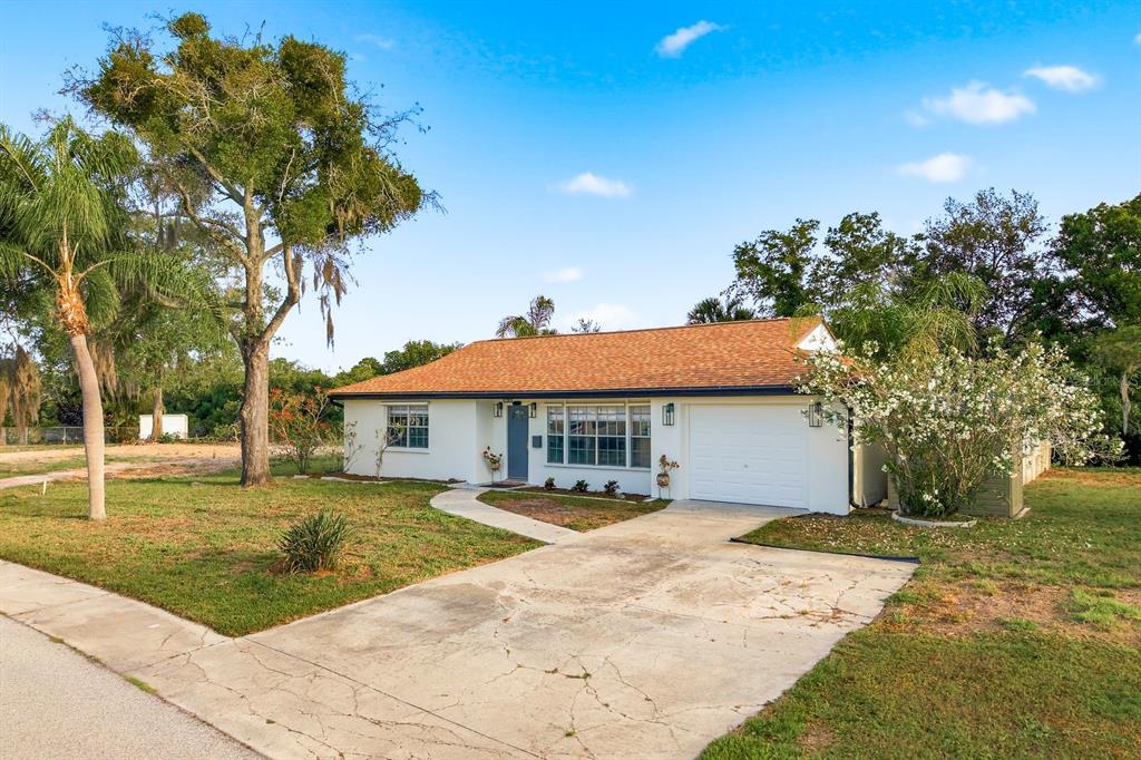 A single-story house with a white exterior, a brown shingled roof, and an attached garage — 3705 GRAYTON DRIVE, NEW PORT RICHEY, FL