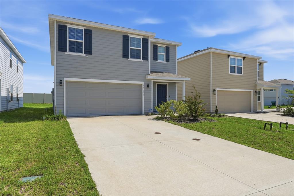 A two-story gray house with a two-car garage and a concrete driveway — 24799 NW 11TH PLACE, NEWBERRY, FL