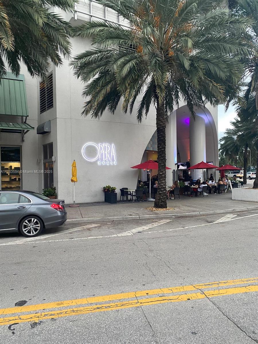 The exterior of the Opera House building features a palm tree and outdoor patio seating — 1750 N Bayshore Dr # 2905, Miami FL 33132, MIAMI, FL