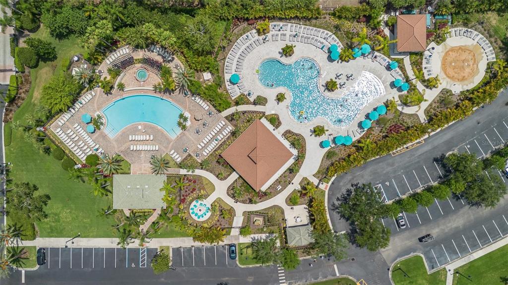 An aerial view shows a community pool complex with two swimming pools, a splash pad, and parking — 4114 BREAKVIEW DRIVE UNIT 110, ORLANDO, FL