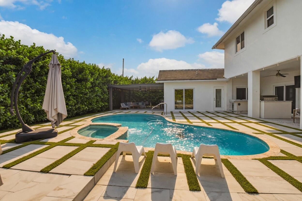 A backyard features a swimming pool, a hot tub, and a patio with artificial turf — 1044 NW 6th Drive, Boca Raton FL 33486, BOCA RATON, FL