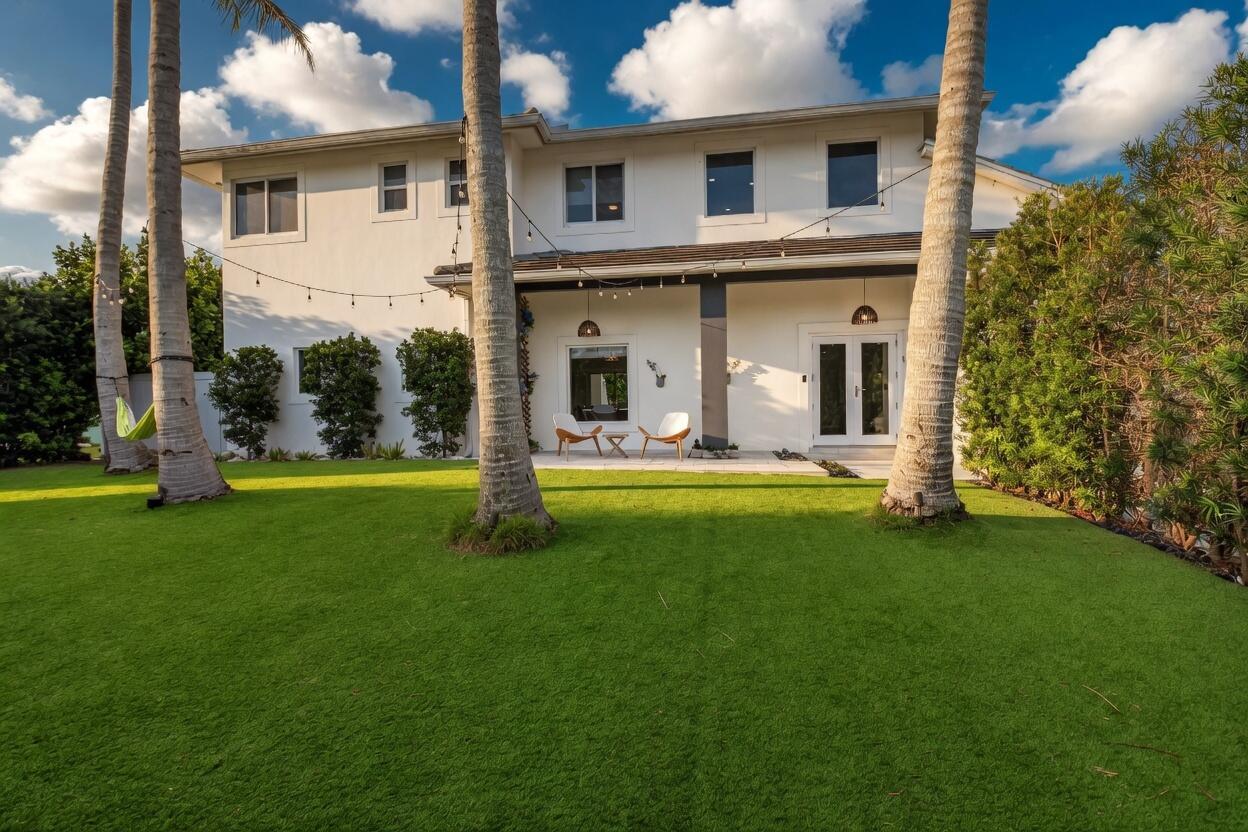 A two-story white house with a backyard patio, palm trees, and string lights — 1044 NW 6th Drive, Boca Raton FL 33486, BOCA RATON, FL