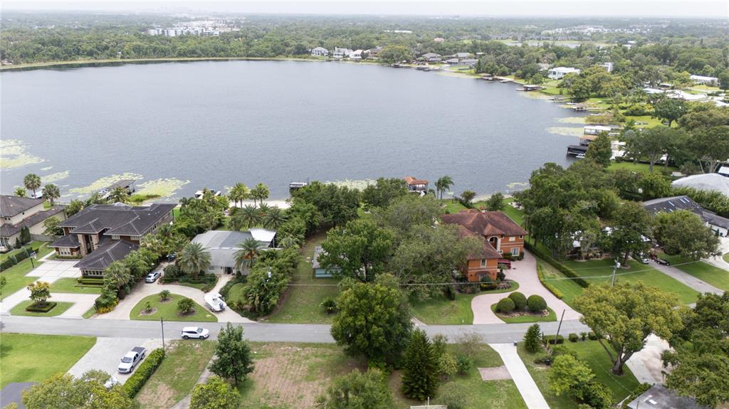 An aerial view shows several waterfront homes with large yards and docks on a lake — 360 LAKE SEMINARY CIRCLE, MAITLAND, FL