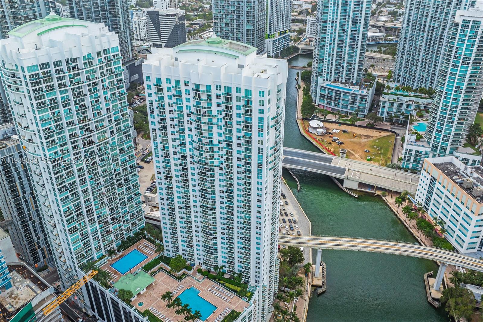 An aerial view shows high-rise apartment buildings, swimming pools, and a bridge over a canal — 31 SE 5th St # 3918, Miami FL 33131, MIAMI, FL