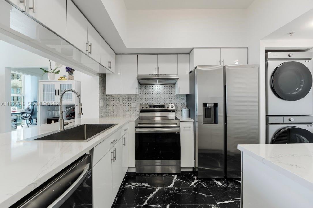 A modern kitchen features white cabinets, stainless steel appliances, and black marble-patterned tile flooring — 31 SE 5th St # 3918, Miami FL 33131, MIAMI, FL