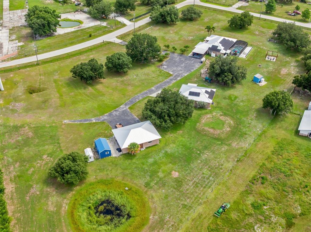 An aerial view shows a rural property with two houses, outbuildings, and a small pond — 8200 CLEVELAND DRIVE, PUNTA GORDA, FL